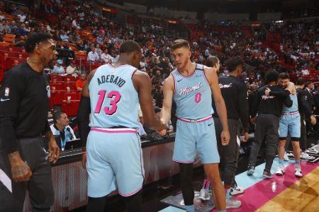 Meyers Leonard in the Miami jersey shaking hands with a teammate.